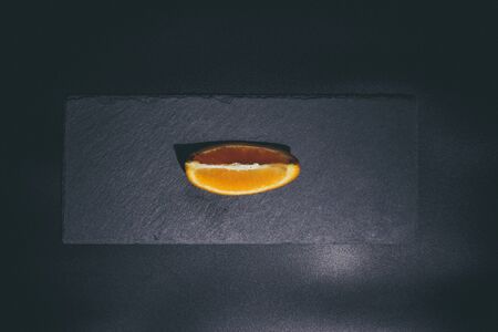Sweet ripe orange on a black surface and black backgroundの写真素材