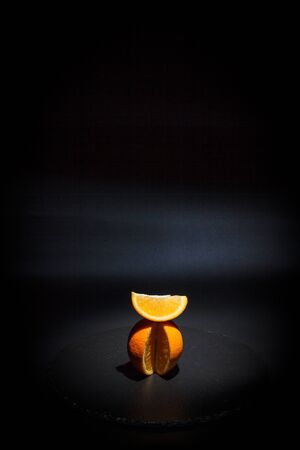 Sweet ripe orange on a black surface and black backgroundの写真素材