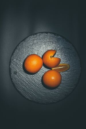 Sweet ripe orange on a black surface and black backgroundの写真素材