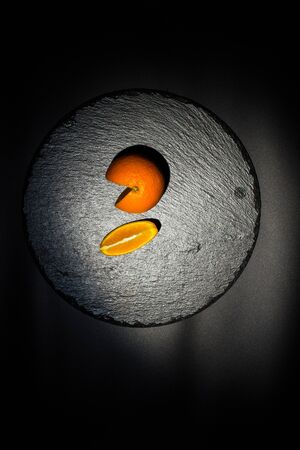 Sweet ripe orange on a black surface and black backgroundの写真素材