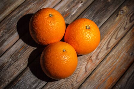 Ripe and tasty orange on a brown wooden surfaceの写真素材
