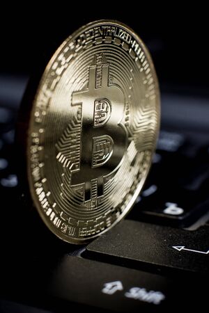 Golden bitcoin on laptop keyboardの写真素材