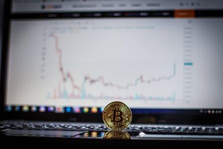 Golden bitcoin on laptop keyboardの写真素材