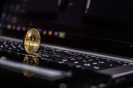 Golden bitcoin on laptop keyboardの写真素材
