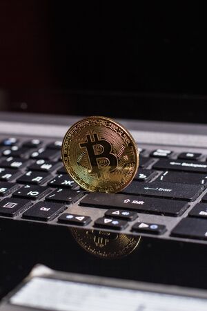 Golden bitcoin on laptop keyboardの写真素材