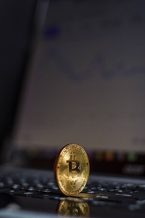 Golden bitcoin on laptop keyboardの写真素材