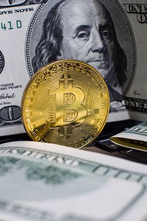 Golden bitcoin and dollars on laptop keyboardの写真素材
