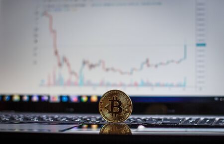 Golden bitcoin on laptop keyboardの写真素材