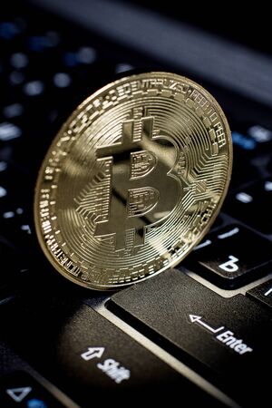 Golden bitcoin on laptop keyboardの写真素材