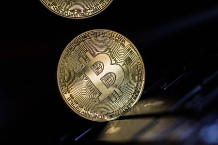 Golden bitcoin on laptop keyboardの写真素材
