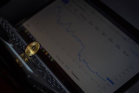 Golden bitcoin on laptop keyboardの写真素材