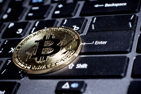 Golden bitcoin on laptop keyboardの写真素材
