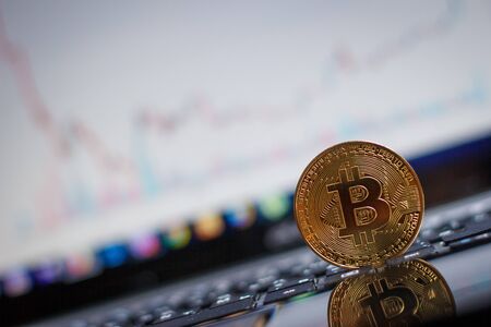 Golden bitcoin on laptop keyboardの写真素材