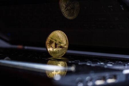 Golden bitcoin on laptop keyboardの写真素材