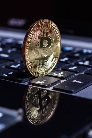 Golden bitcoin on laptop keyboardの写真素材