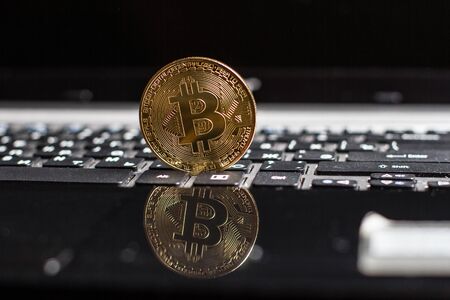 Golden bitcoin on laptop keyboardの写真素材