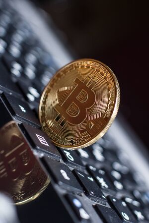 Golden bitcoin on laptop keyboardの写真素材