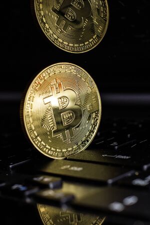Golden bitcoin on laptop keyboardの写真素材