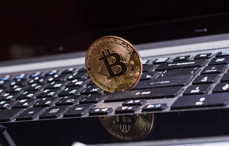 Golden bitcoin on laptop keyboardの写真素材