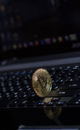 Golden bitcoin on laptop keyboardの写真素材
