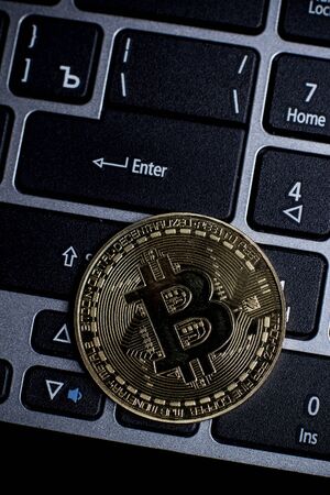 Golden bitcoin on laptop keyboardの写真素材