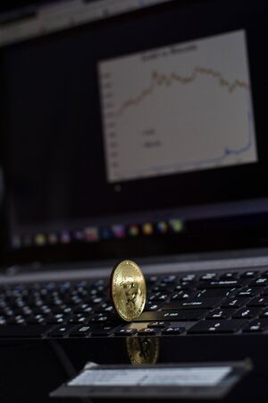 Golden bitcoin on laptop keyboardの写真素材
