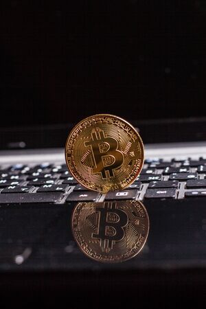 Golden bitcoin on laptop keyboardの写真素材