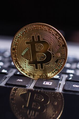 Golden bitcoin on laptop keyboardの写真素材