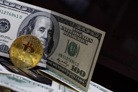 Golden bitcoin and money on laptop keyboardの写真素材