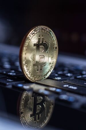 Golden bitcoin on laptop keyboardの写真素材