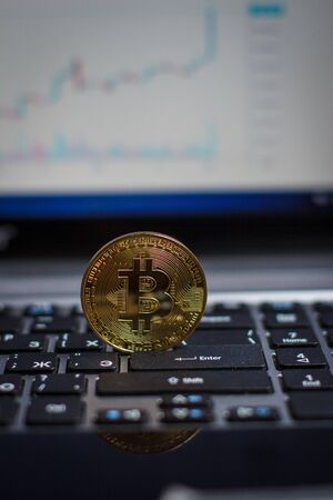 Golden bitcoin on laptop keyboardの写真素材