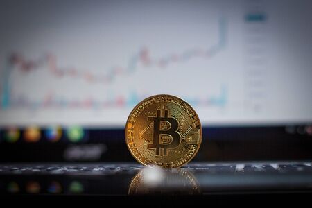 Golden bitcoin on laptop keyboardの写真素材