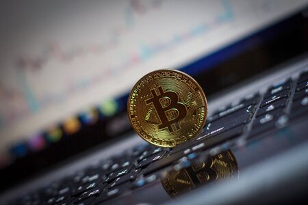Golden bitcoin on laptop keyboardの写真素材