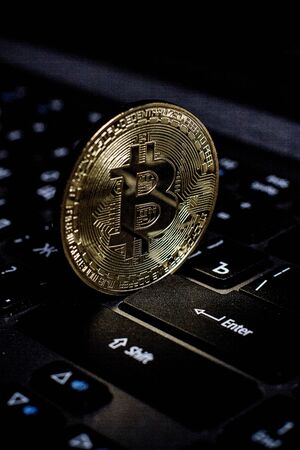 Golden bitcoin on laptop keyboardの写真素材