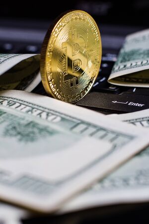 Golden bitcoin and money on laptop keyboardの写真素材