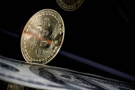 Golden bitcoin and money on laptop keyboardの写真素材