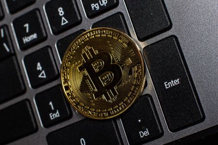 Golden bitcoin on laptop keyboardの写真素材