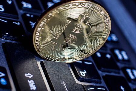 Golden bitcoin on laptop keyboardの写真素材