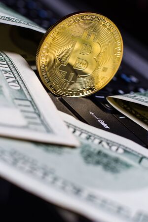 Golden bitcoin and money on laptop keyboardの写真素材