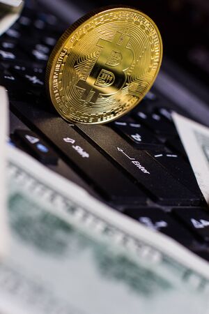 Golden bitcoin on laptop keyboardの写真素材