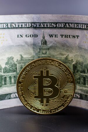 Bitcoin coin on a background of dollarsの写真素材
