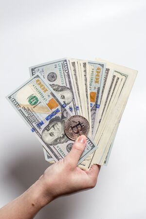 In the hand a lot of money and bitcoin.の写真素材