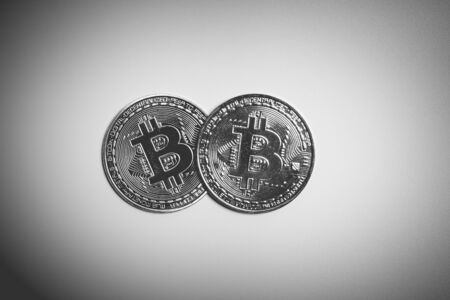 Two bitcoins in black and white light