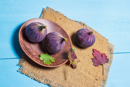 Ripe figs on a blue wooden surfaceの写真素材