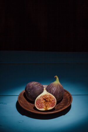 Ripe figs on a blue wooden surface