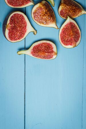 Ripe figs on a blue wooden surfaceの写真素材