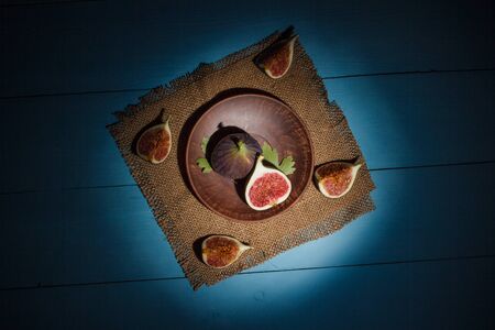 Ripe figs on a blue wooden surfaceの写真素材