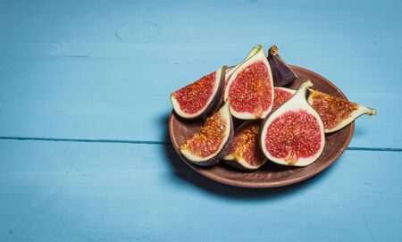 Ripe figs on a blue wooden surfaceの写真素材