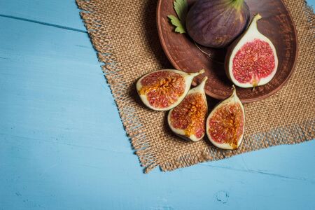 Ripe figs on a blue wooden surfaceの写真素材