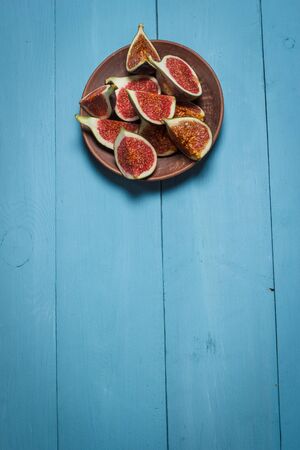 Ripe figs on a blue wooden surfaceの写真素材